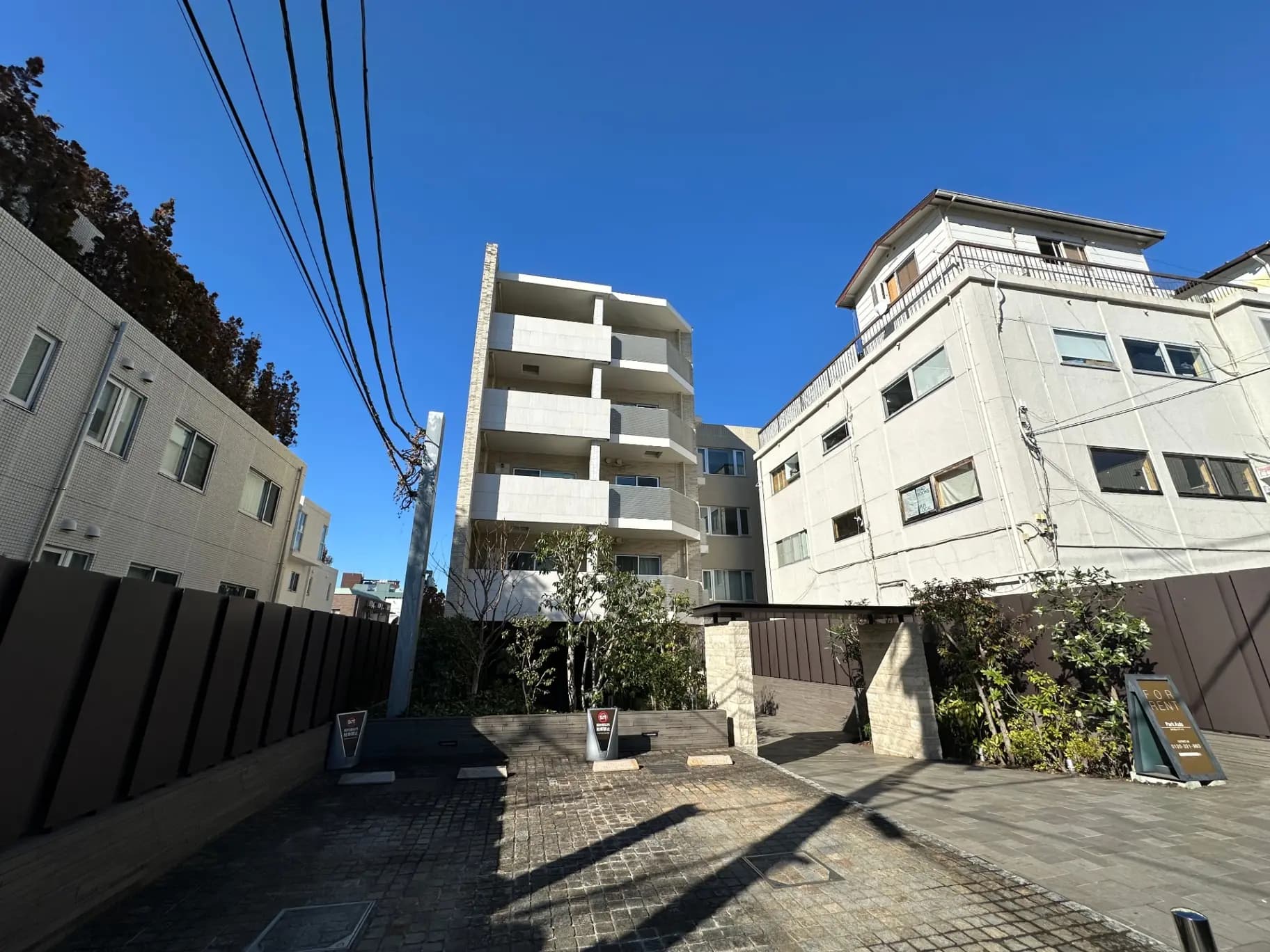 晴れた日の都市風景、中層マンションと周辺の住宅、クリアな青空