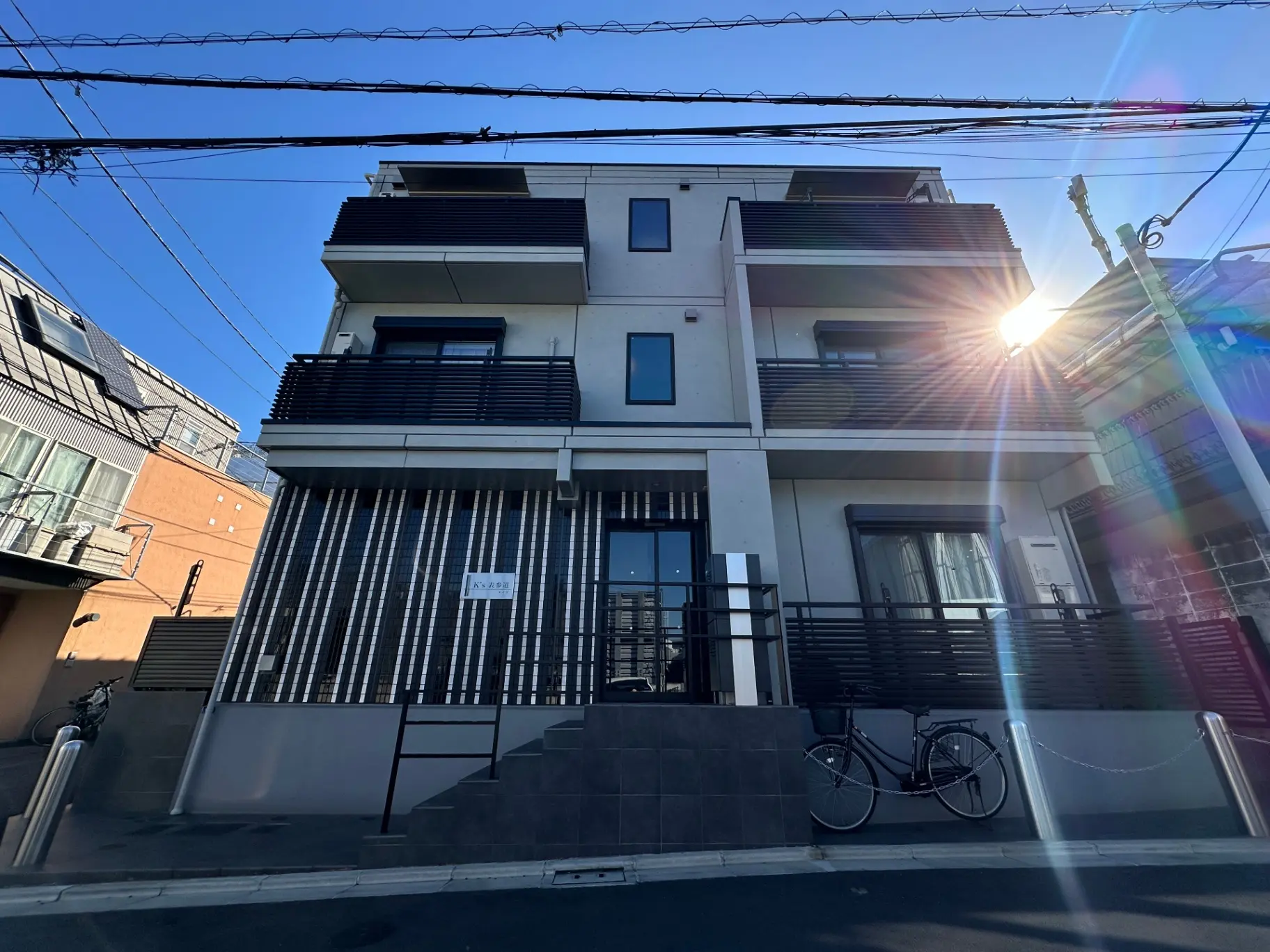日差しの中のモダンな外観の都市型アパート、バルコニー付き、自転車が駐輪されているシーン