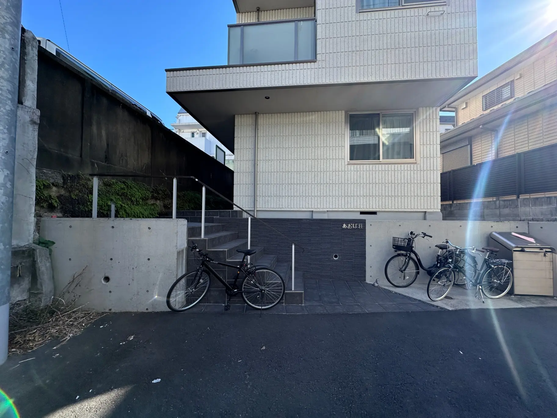 都会的な住宅の外観、駐輪スペースに自転車が停められている光景