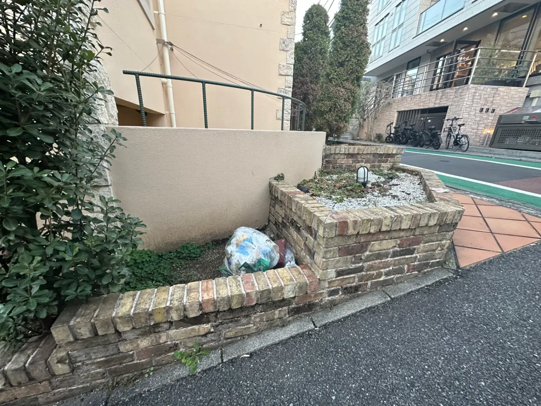 建物の入り口近くの自転車置き場と小さな植栽スペース