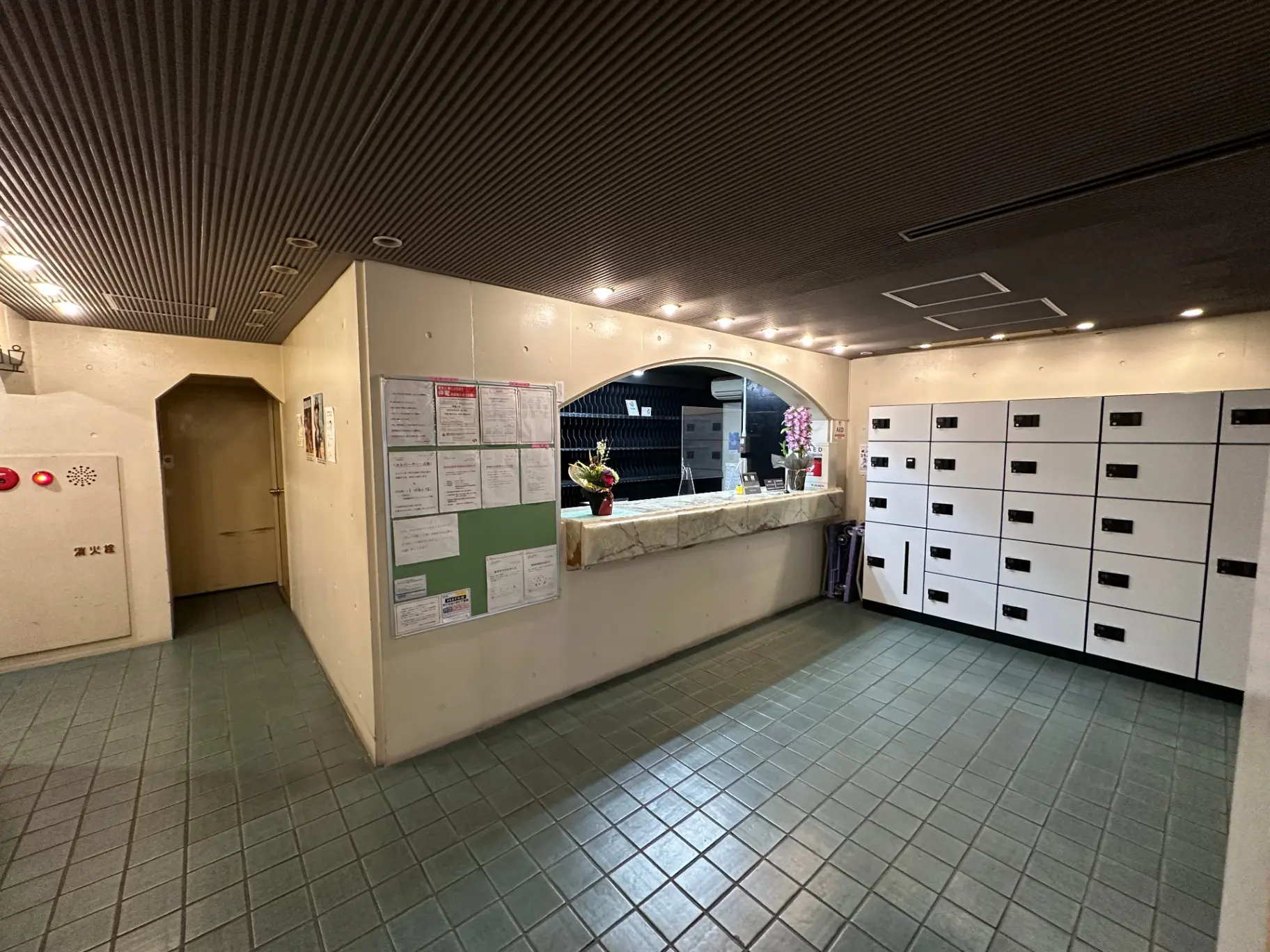 マンションのエントランスホール、宅配ボックスと掲示板が設置されている清潔な内装