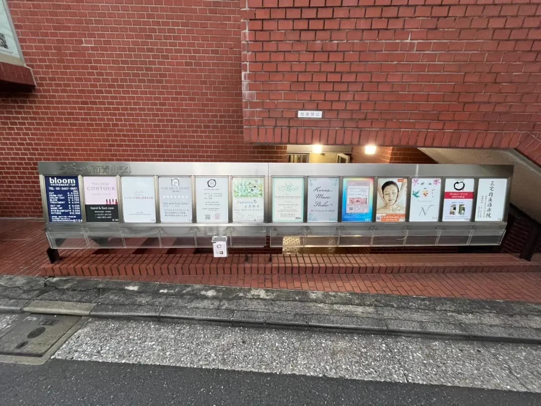 レンガ壁に設置されたビジネスの案内看板、歩道と階段の都市風景