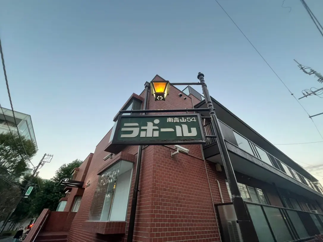レンガ造りの建物と夕暮れの空、街角のラベルつき街灯