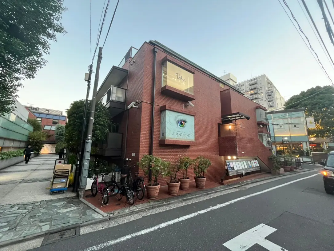 都会の角地に建つ赤レンガ造りのモダンなビル、アイテーマのアートが特徴的な外観デザイン