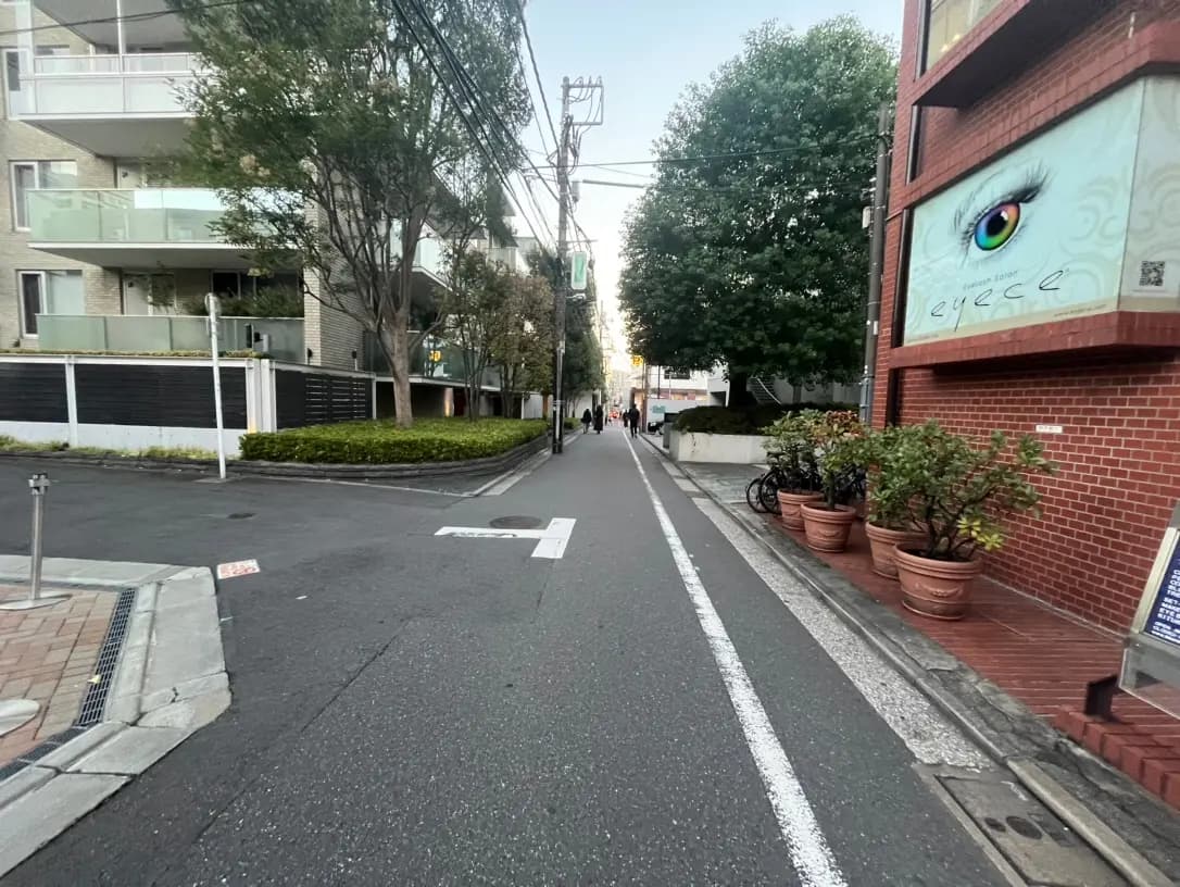都市の通りの景色、歩行者と自転車、壁に描かれた大きな目のアートワーク