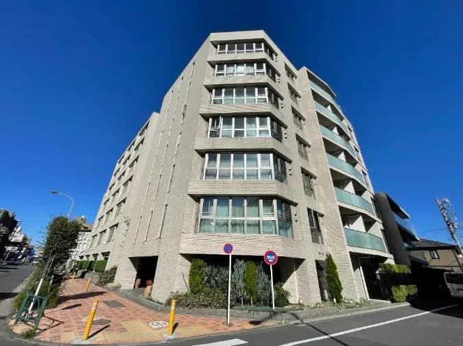 モダンな外観の高層マンション、晴天の下で青空が広がる街角の風景