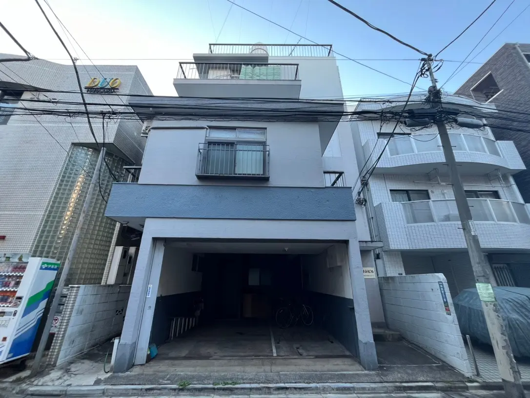 日本の都市の狭い通りにある現代的な住宅とアパート、駐車場と自転車のスペースがある建物