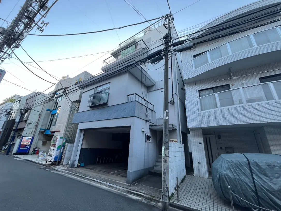 日本の住宅街の景色、電線が多く張り巡らされた通り、建物は密集しており空は青い