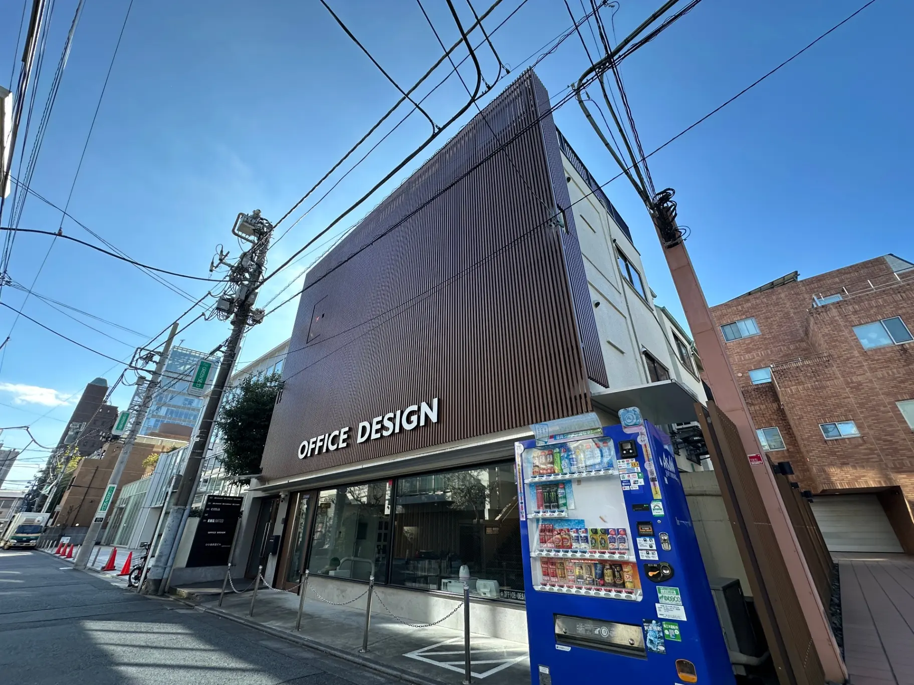 現代的な建築デザインのオフィスビルと自動販売機がある都市の通り
