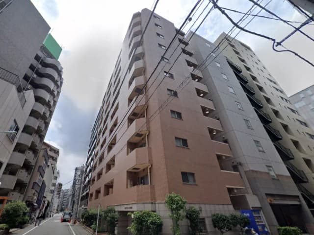 - 都市部に立地する8階建ての集合住宅、近代的なデザインとバルコニーが特徴的、周囲には商業施設が点在する住宅エリアの風景