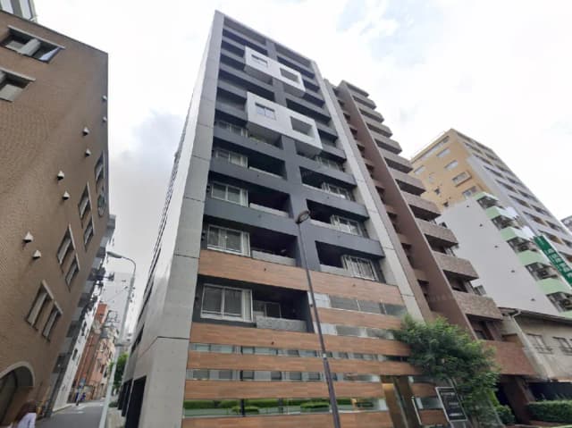 - モダンな外観の8階建てマンション、木目調のバルコニーとコンクリート壁が特徴的なデザイン、周囲の街並みとのコントラストが美しい景観