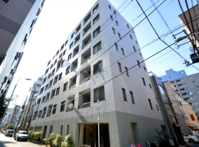 - 近代的なデザインの4階建てアパートメント、窓が多数あり、周囲に車と緑の植栽が見える街並み