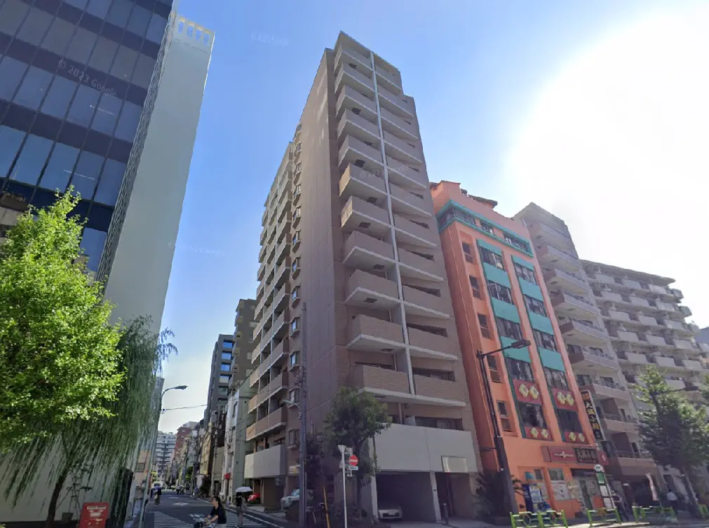 - 都心の高層マンション群と青空、緑豊かな街路樹が並ぶ商業区域の風景
