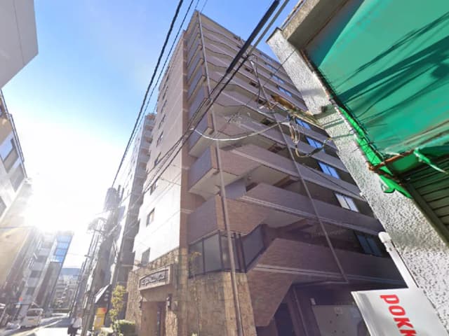 - 高層ビルの外観、晴れた青空と街の風景が見える角度から撮影された画像、建物の階段と窓のデザインが特徴的