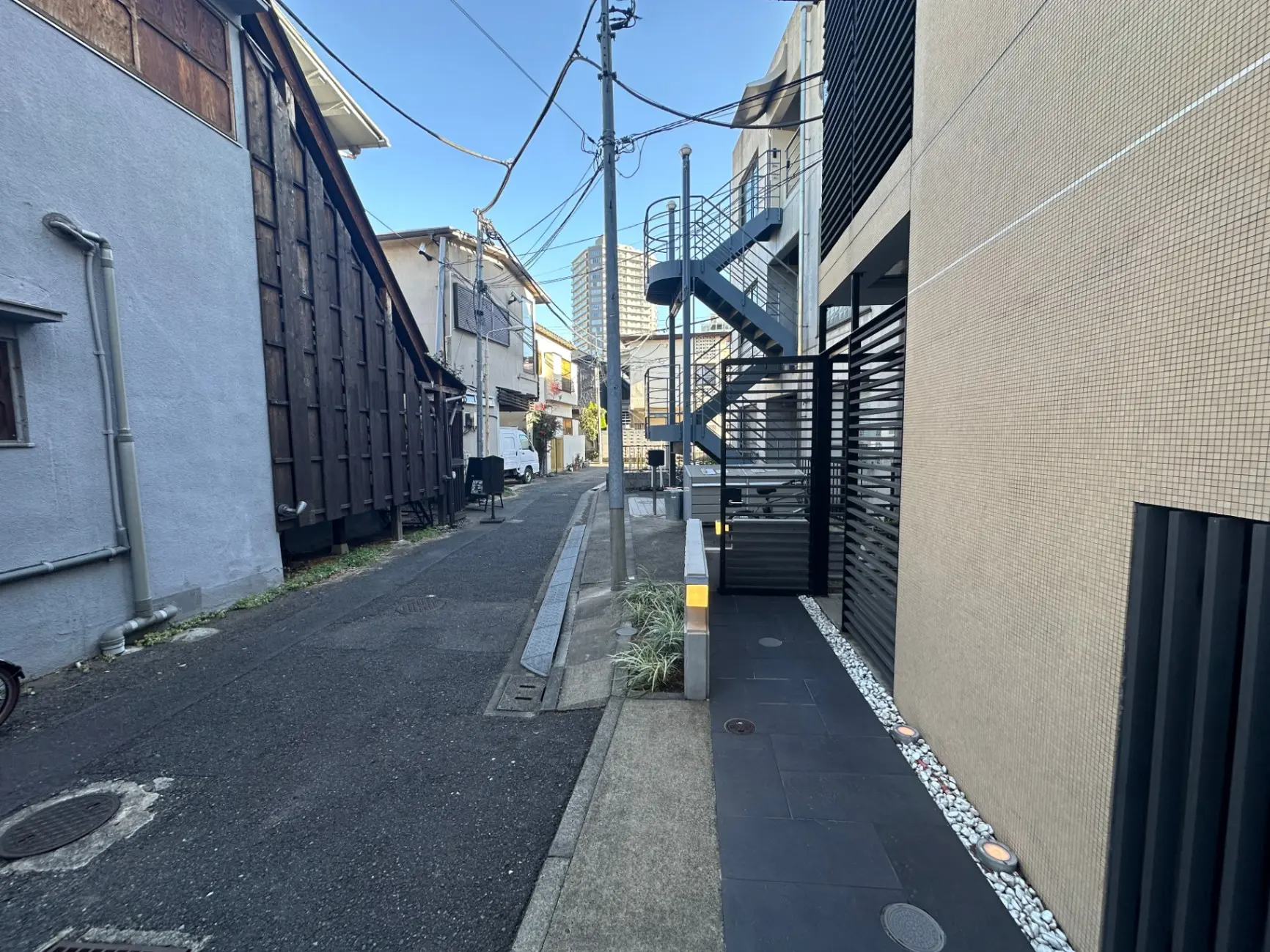 日本の狭い路地と現代的な建築、外階段と石膏ボードの外壁デザイン