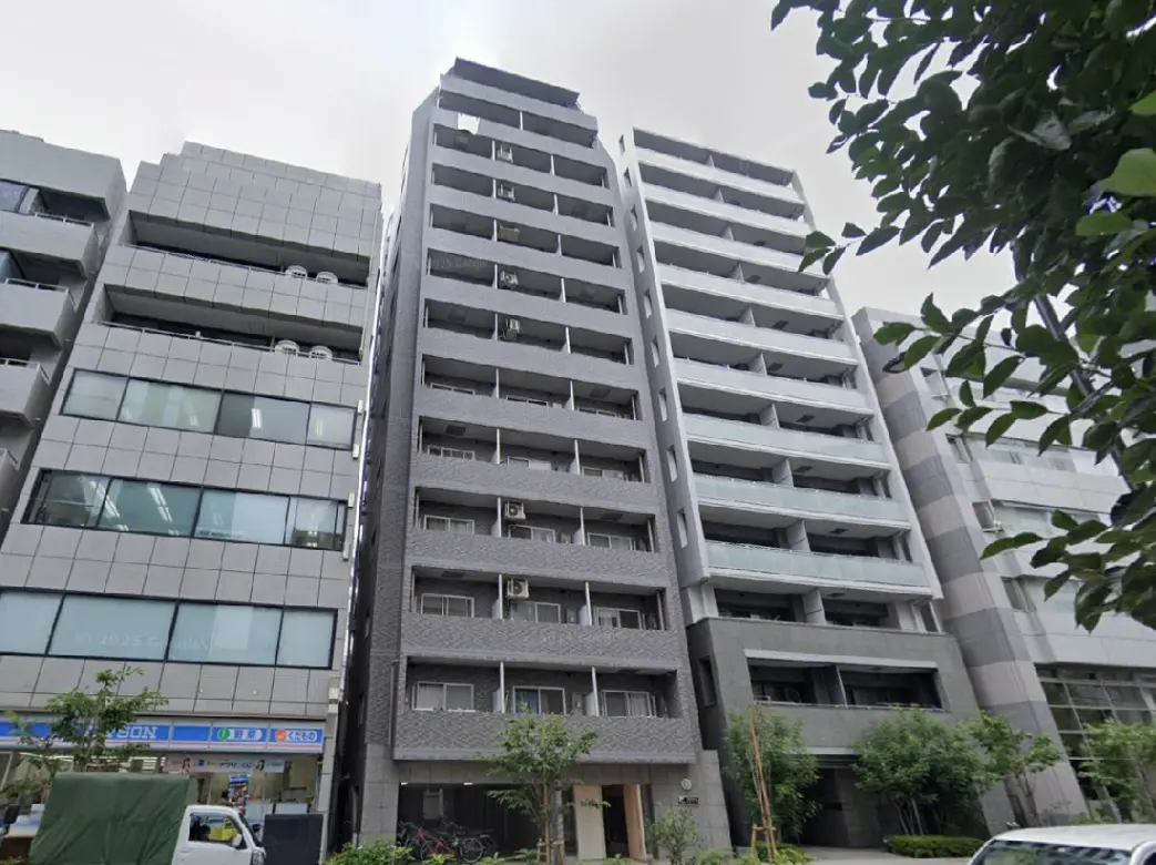 - モダンなデザインの高層マンション、周囲に商業施設と緑があり、都市部の生活を反映した外観