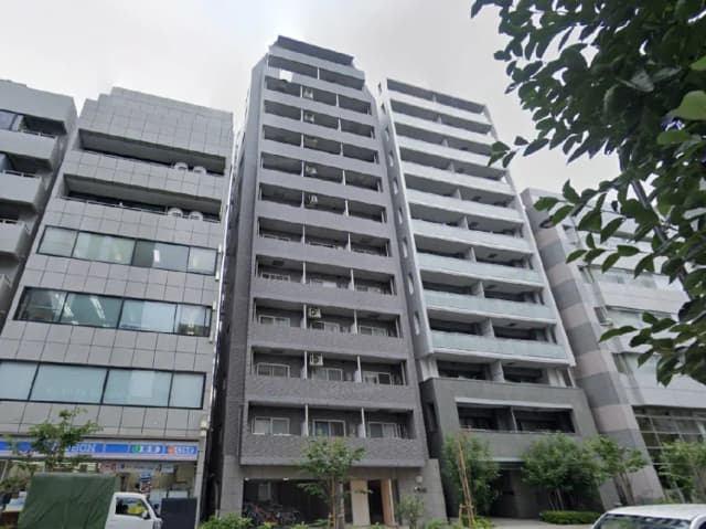 - モダンなデザインの高層マンション、周囲に商業施設と緑があり、都市部の生活を反映した外観