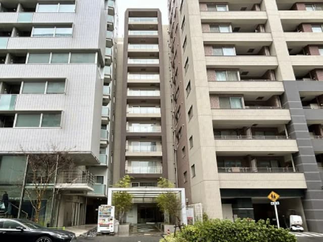- いくつかの現代的なマンションが立ち並ぶ街並み、1階にエントランスが見える構図