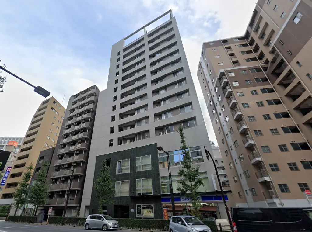 - 現代的なデザインの高層マンション、周囲に他のビルが立ち並ぶ都市風景の一部