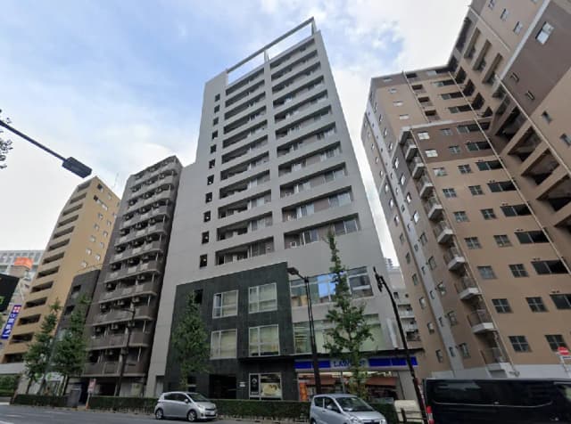 - 現代的なデザインの高層マンション、周囲に他のビルが立ち並ぶ都市風景の一部