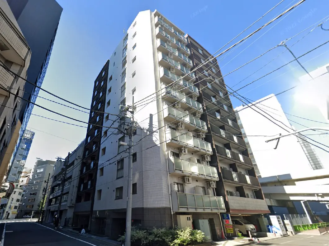 - 近代的な高層マンションの外観、周囲のビルと電線が交錯する街並みの風景