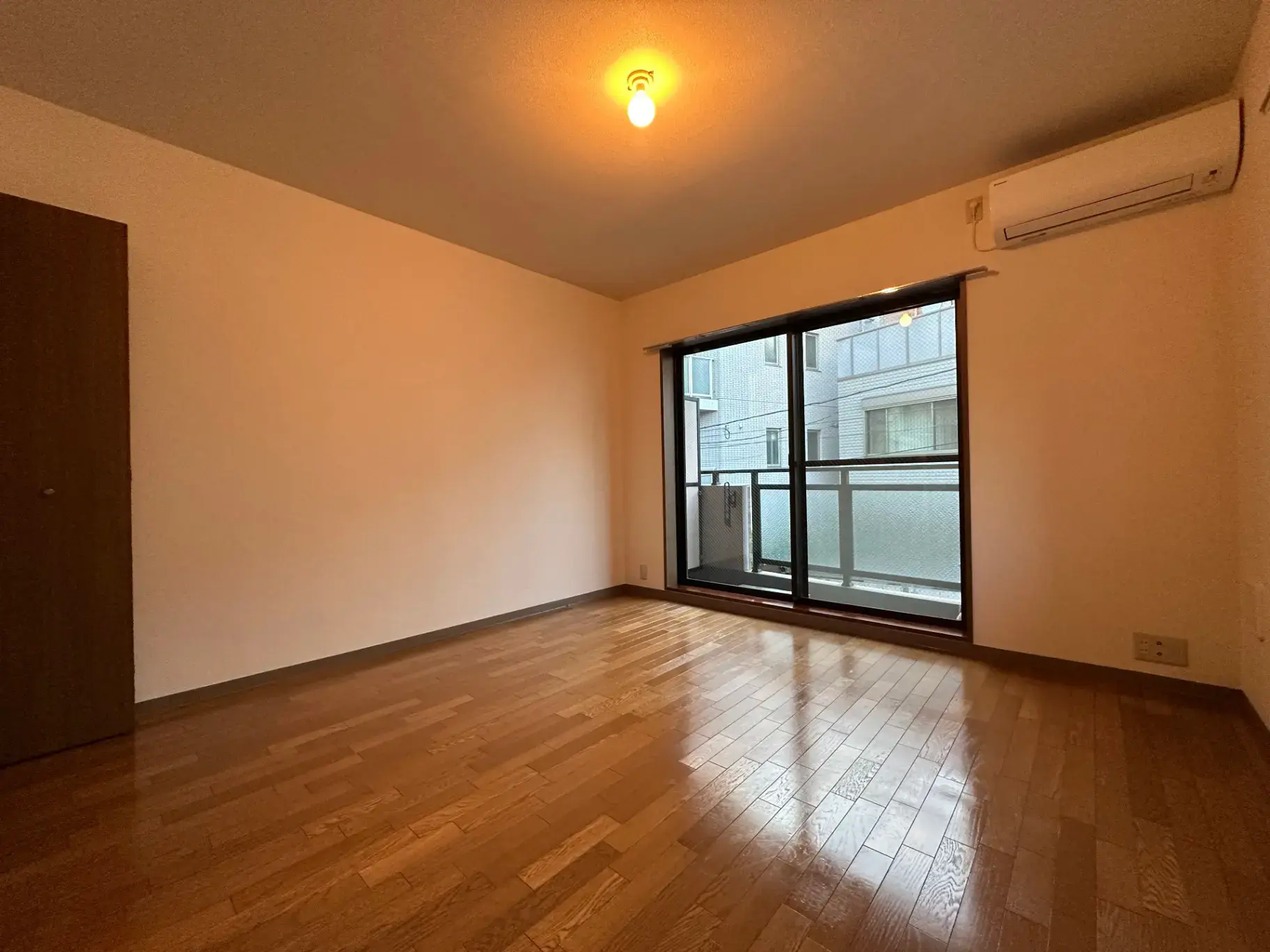 エアコン付きの広々とした明るいリビングルーム、大きな窓から自然光が差し込む