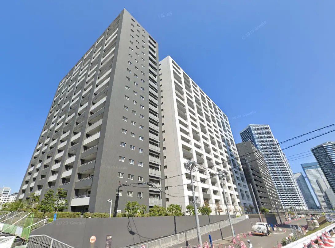 - モダンな高層マンションの外観、大きなバルコニーと明るい青空を背景にした建物の画像