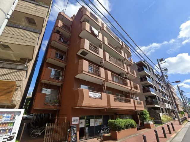 日本の住宅街にある茶色の多層アパートビル、晴れた日の外観と自転車駐輪スペース