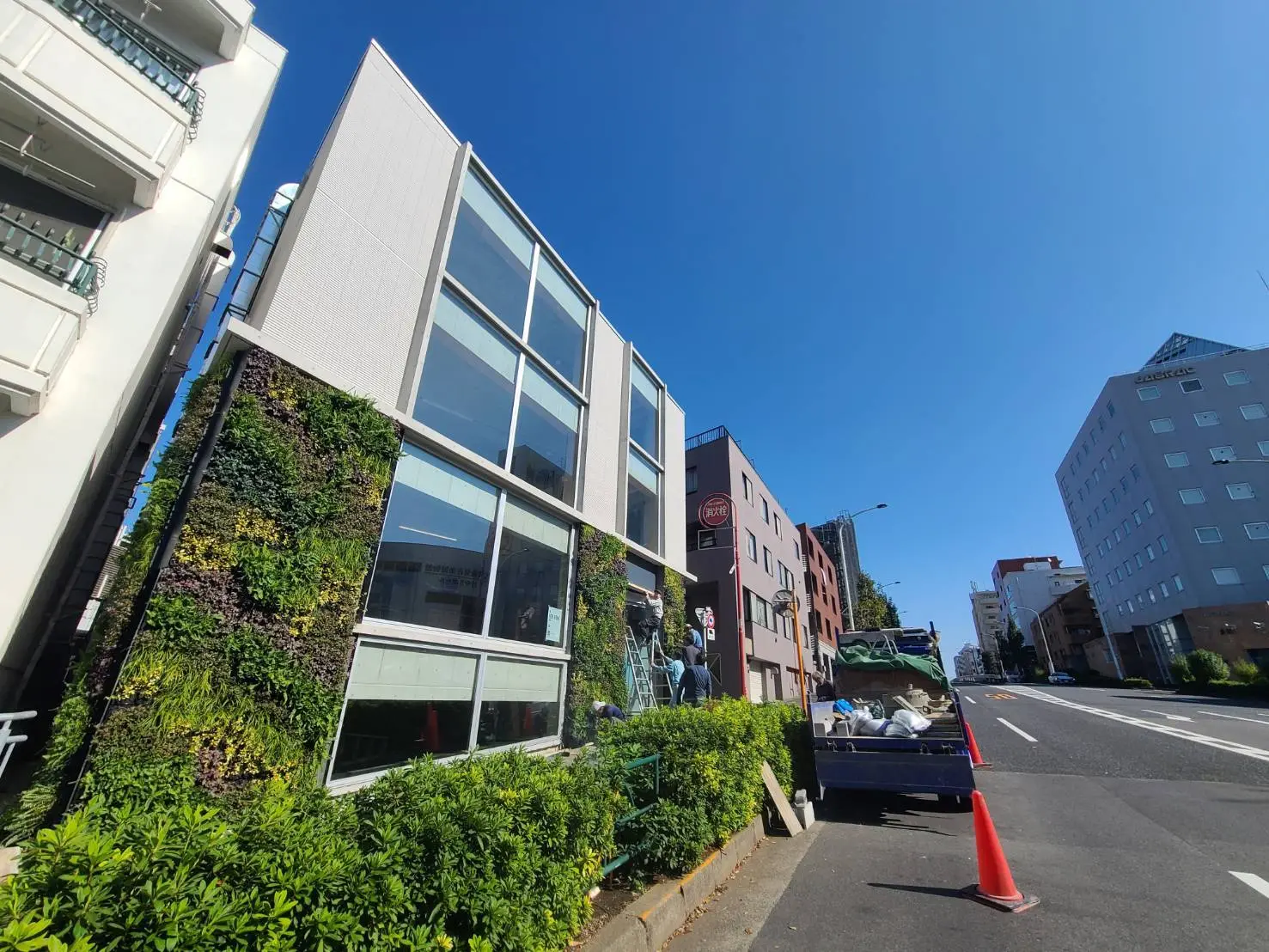 都市のオフィスビルと緑豊かな垂直庭園、晴れた日の青空