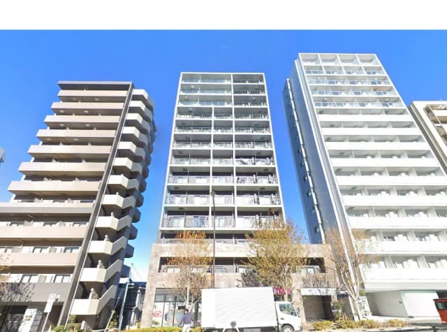 - 都市型の高層マンション群、青空の下に並ぶ現代的な外観とバルコニーのある住居の風景