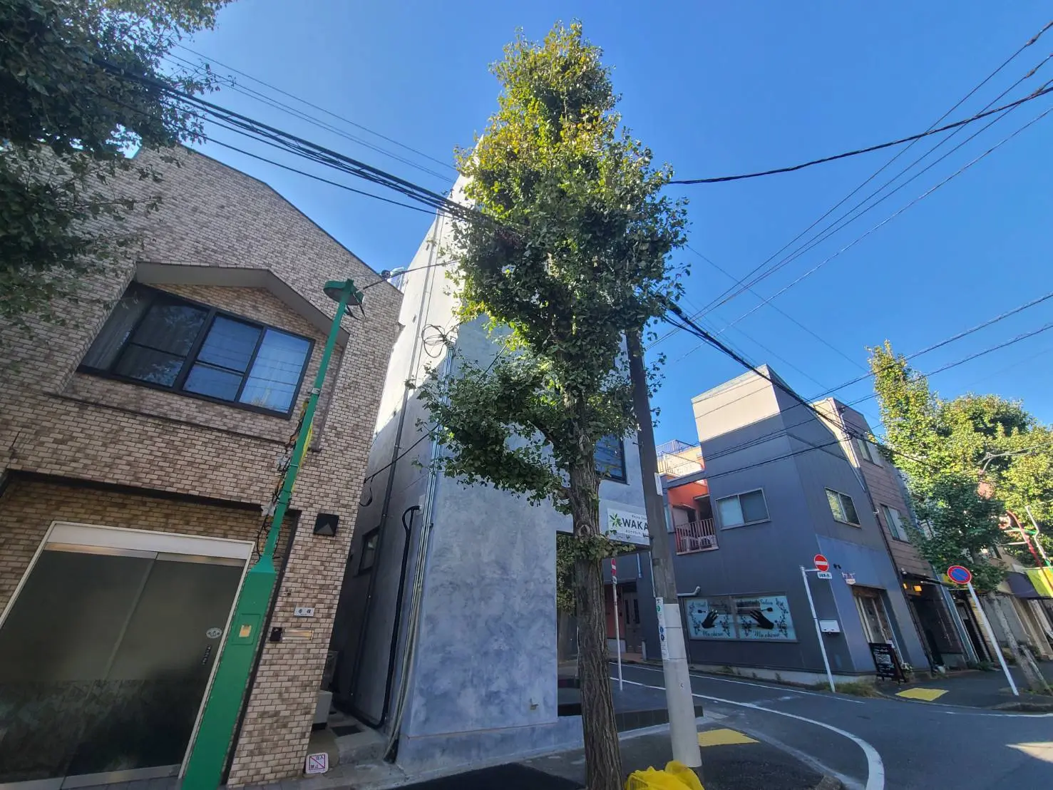都市の角地に位置する現代的なデザインの建物と青空