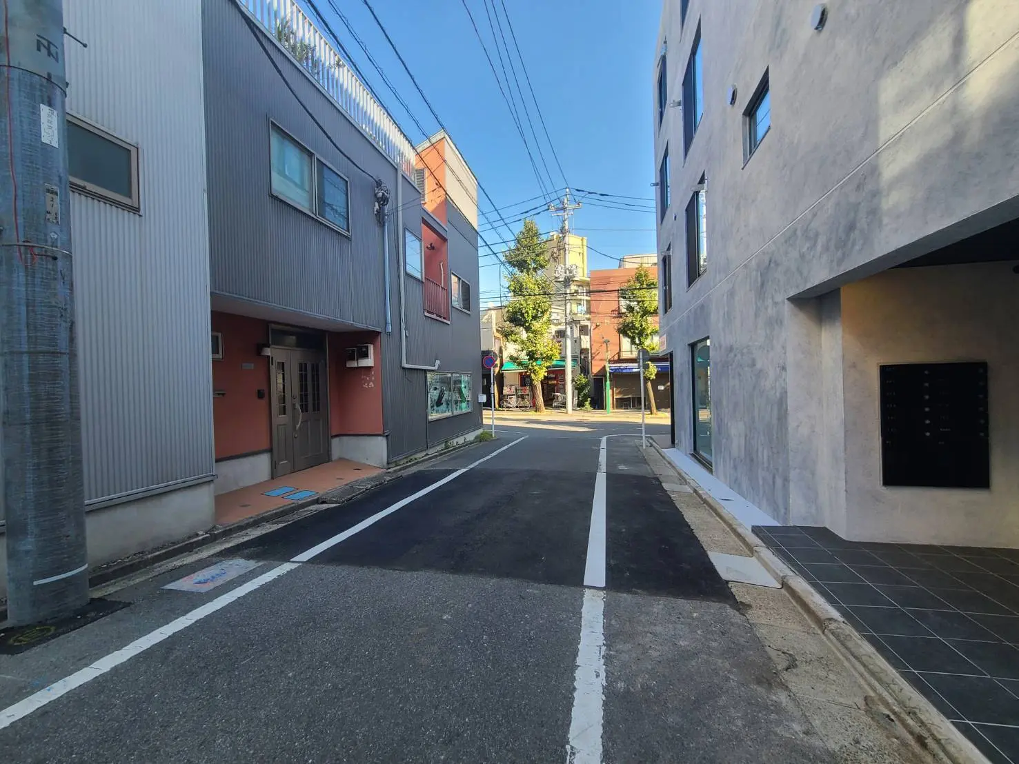 晴れた日の都市の道路、モダンな建物の外観、歩道と駐車スペースが整備されている風景