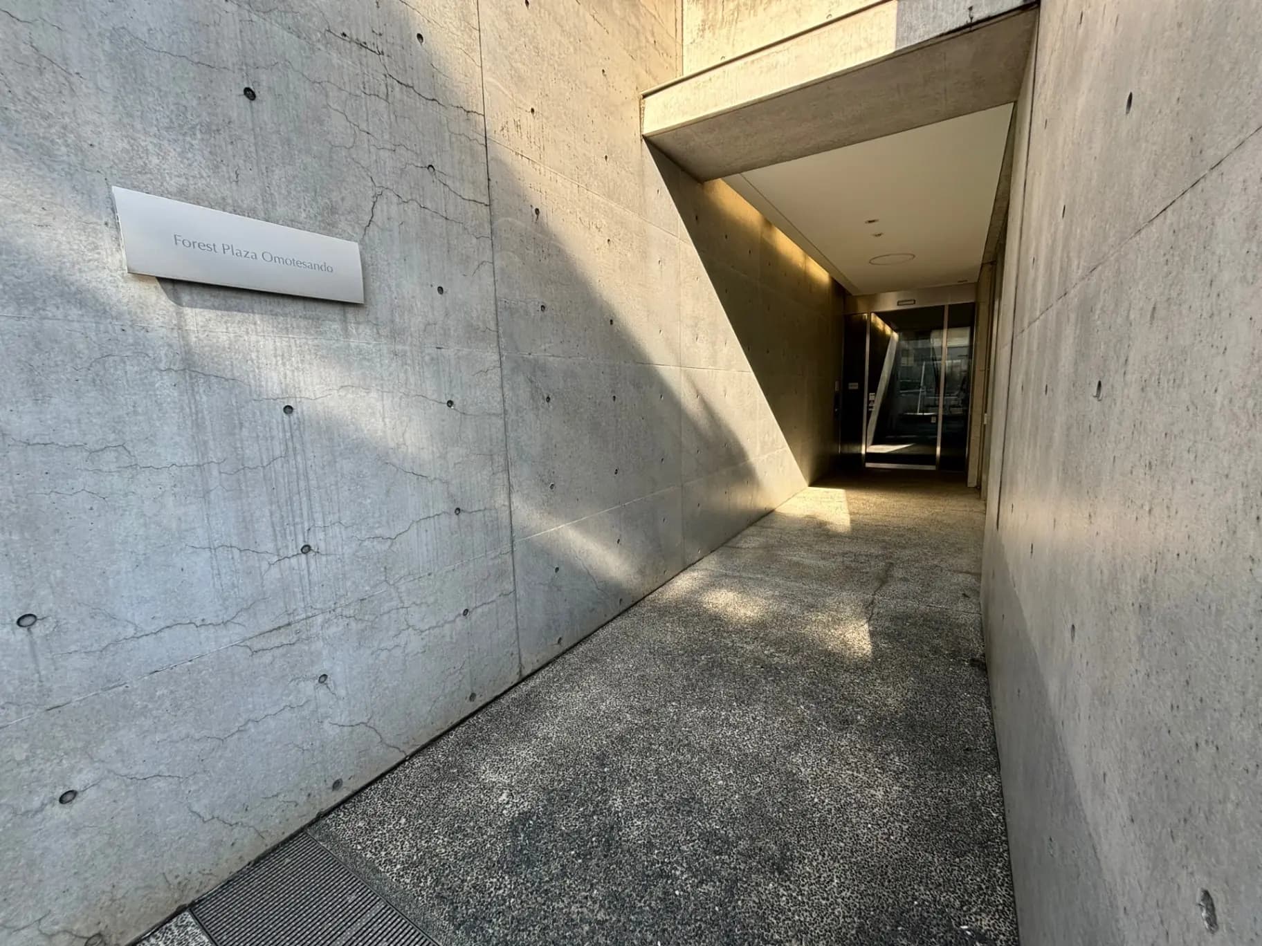 表参道にあるモダンな建築デザインのフォレストプラザ入り口、コンクリートの壁と広々としたアプローチ