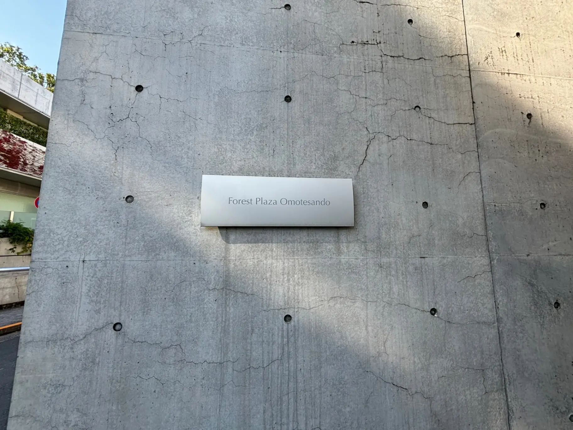 コンクリートの壁面に取り付けられた「Forest Plaza Omotesando」と書かれた看板