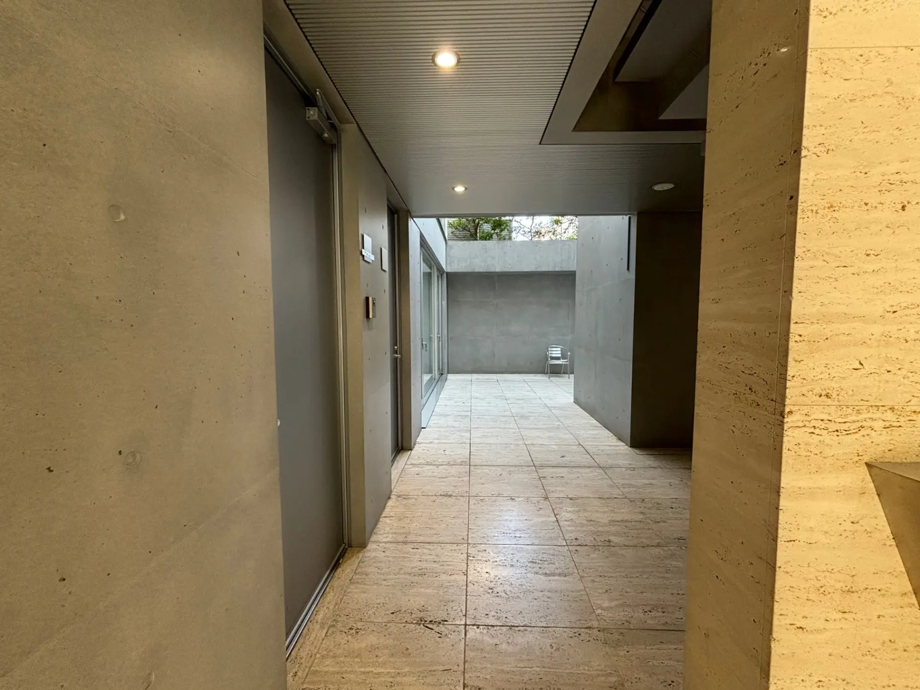 モダンアーキテクチャの屋外廊下、洗練されたコンクリートデザイン、照明付き天井