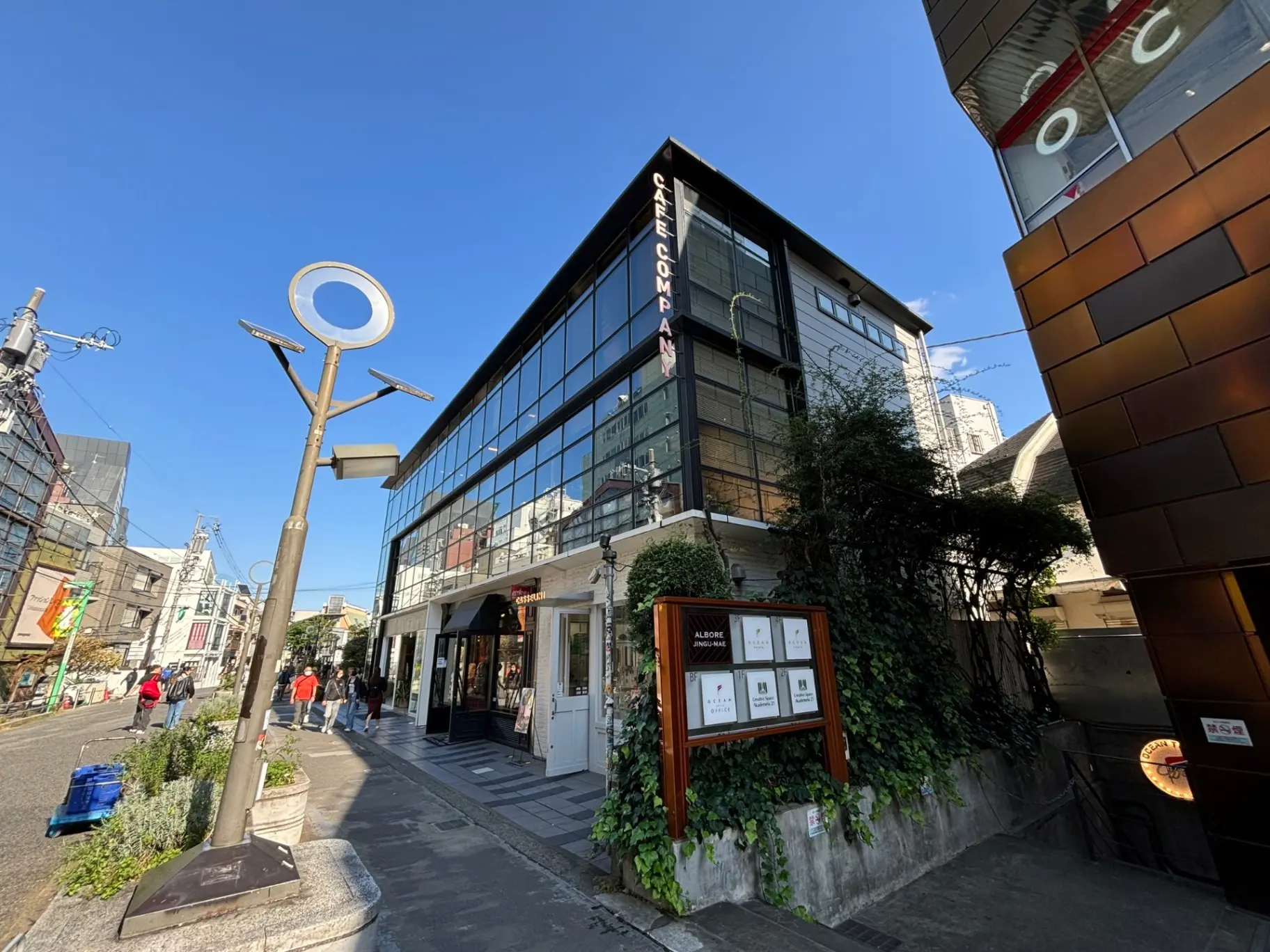 日差しが差し込む快晴の日に撮影された都会のオシャレなカフェとショップが立ち並ぶ通り