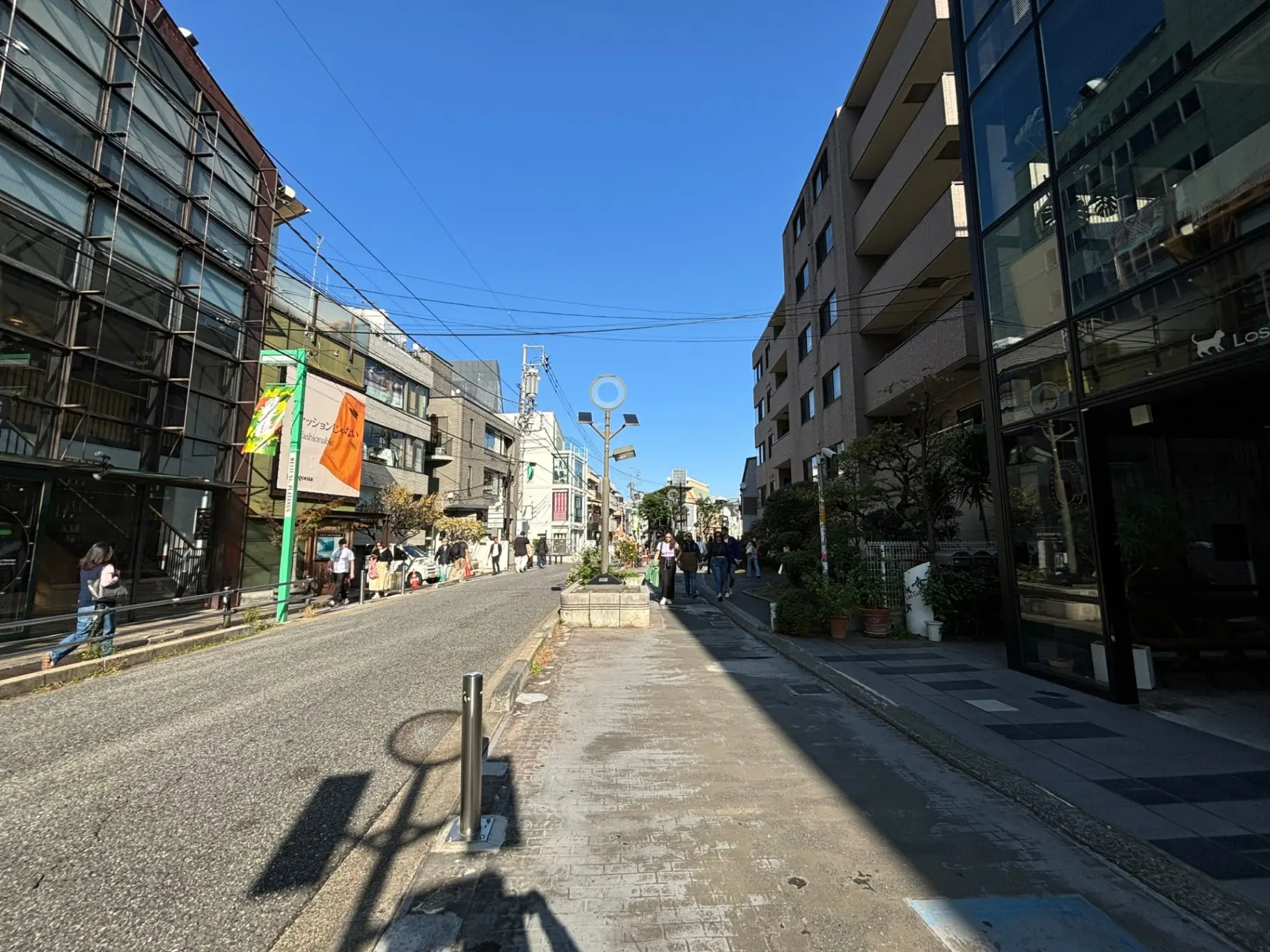 晴れた日の都市風景、人々が歩く歩道、店舗が並ぶ街並み