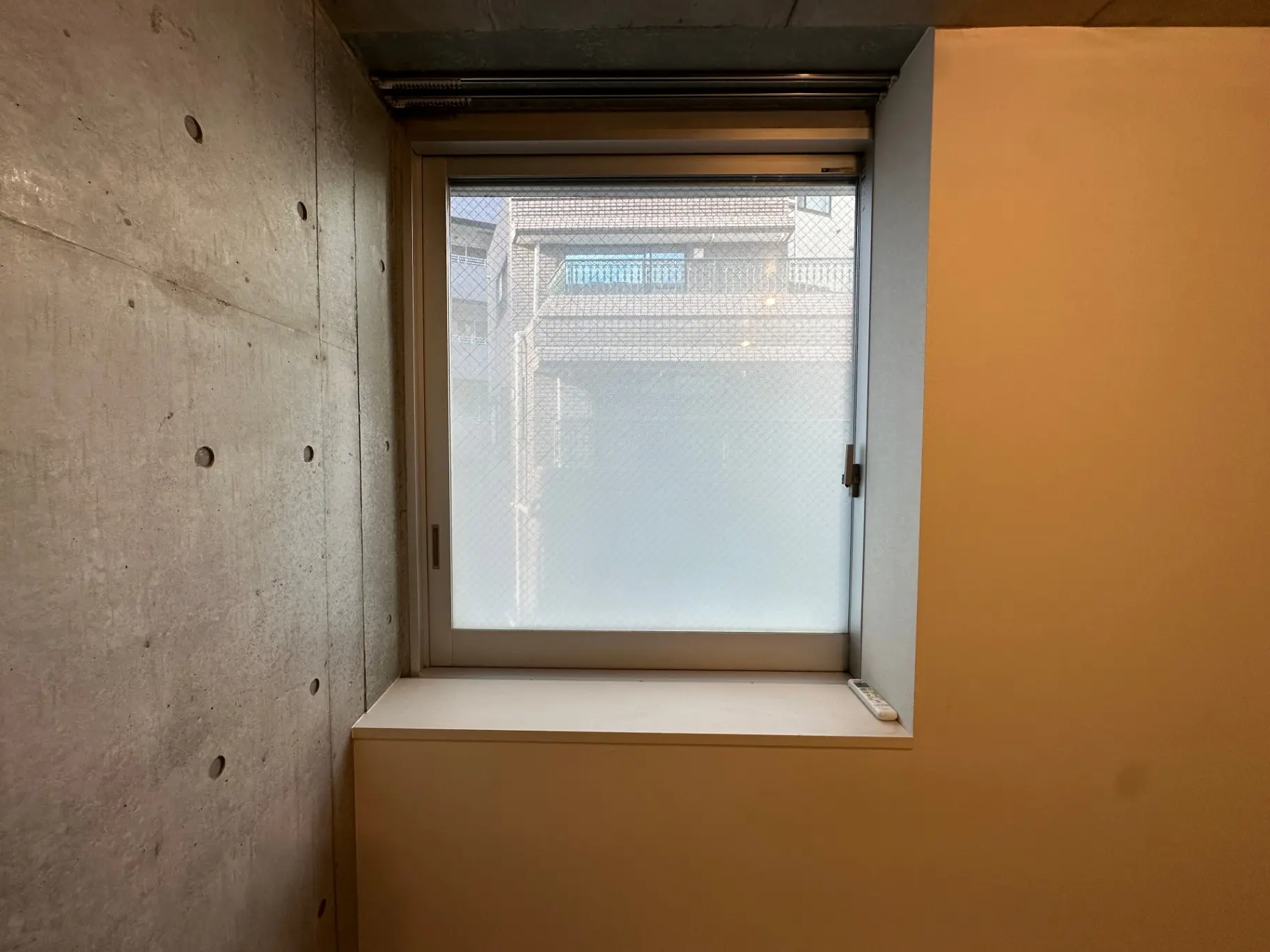 シンプルなインテリアの部屋のコンクリート壁と小さい窓、日当たりが良い空間
