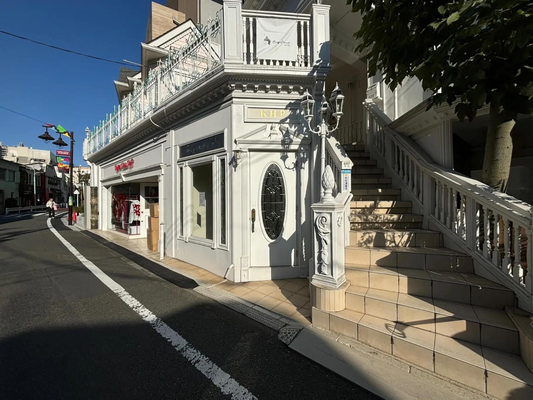 クラシカルなデザインのショップ外観、洗練された階段と街灯、晴れた天気の下の都市風景