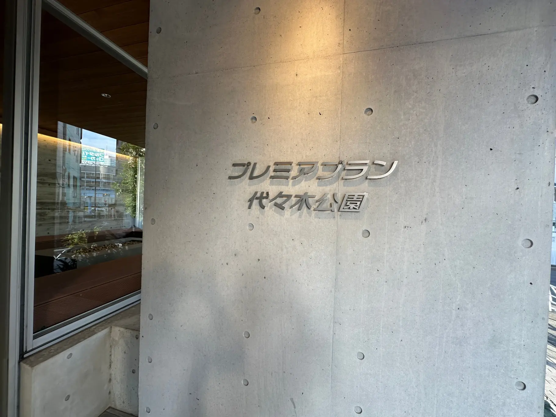コンクリート壁に刻まれた「プレミアムタイヤ本舗」という文字のロゴデザイン