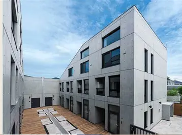 - コンクリート外観のモダンな建物、広々とした中庭と大きな窓を備えたデザイン