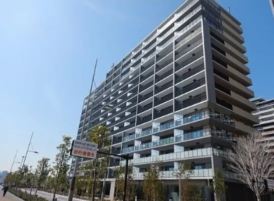 青空の下、モダンな複数階建てマンションの外観、都市の高層住宅デザイン