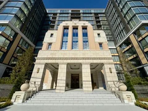 - モダンなデザインの高級マンションの外観、正面の大階段と対称的な造形が特徴的で、周囲には緑が広がる風景