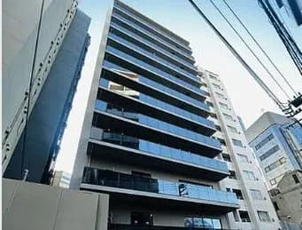 現代的なマンションの外観、青空に映える多階建て建築、街中の立地条件