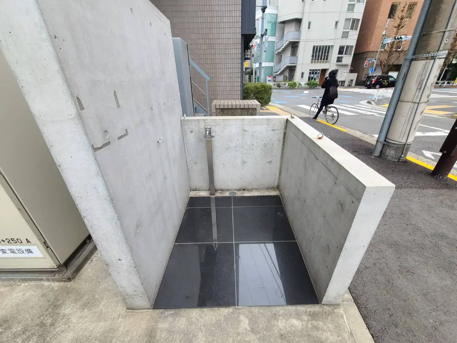コンクリート打ちっぱなしの階段と手すりが特徴的なエントランス