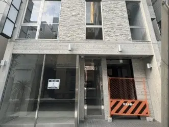 建築中のモダンなオフィスビルの外観、石の壁面、ガラスの入り口、足場が設置されている状態