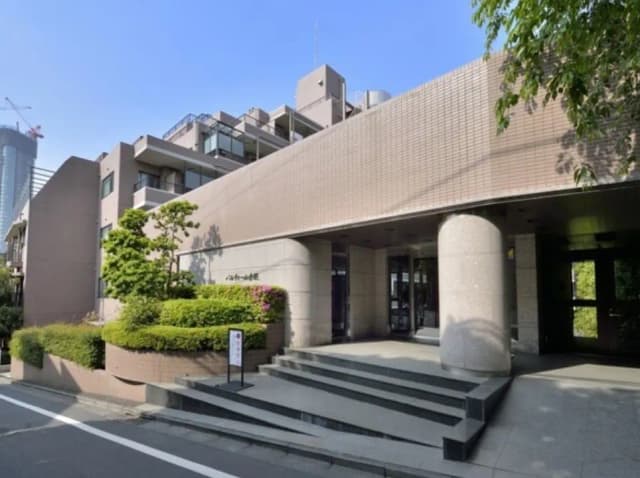 都市の中にあるモダンな建築スタイルのオフィスビル入り口、緑の植栽と幅広い階段