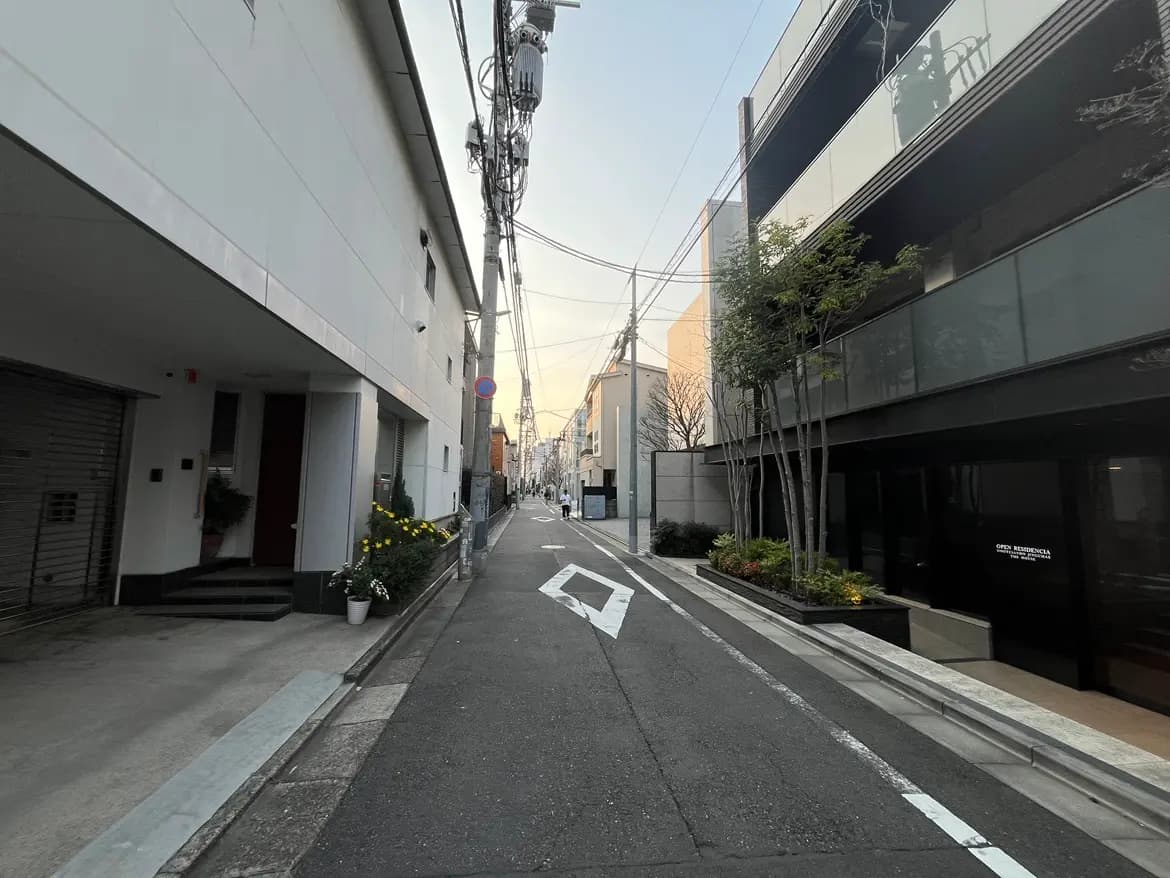日本の都市の住宅街、早朝の空が広がる静かな通り、モダンな建築と電線