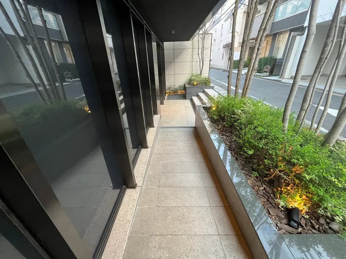 モダンな外観の都市型住宅施設の歩道と緑豊かな植栽エリア