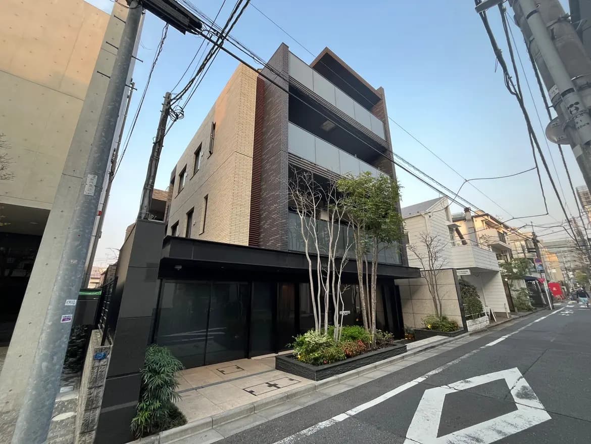 モダンで洗練された外観の都市型ビル、通りに面して建つ、小規模な樹木と植栽がある